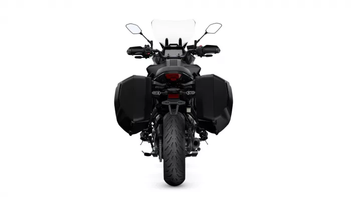 Rear view of a black adventure/touring motorcycle with hard side panniers and a tall windscreen
