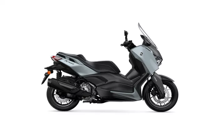 Side view of a grey Yamaha XMAX sport scooter, showing its windshield and front wheel on the right