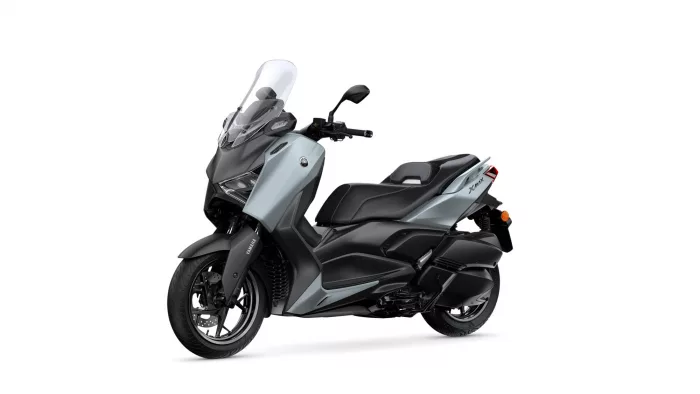 Gray Yamaha XMAX scooter with a tall clear windshield, angled side view showing front and seat.