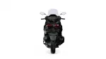 Rear view of a black sport motorcycle with red taillights and a tall windshield against a white background.