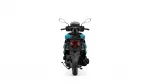 Rear view of a teal-and-black motorcycle with handlebars and mirrors visible, taillight centered at the back, white backdrop