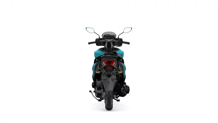 Rear view of a teal-and-black motorcycle with handlebars and mirrors visible, taillight centered at the back, white backdrop
