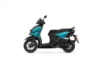 Side view of a teal and black Yamaha scooter, showing front and rear wheels and seat.