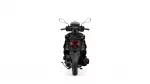 Rear view of a black motorcycle/scooter showing the taillight, seat, and rear wheel from behind.