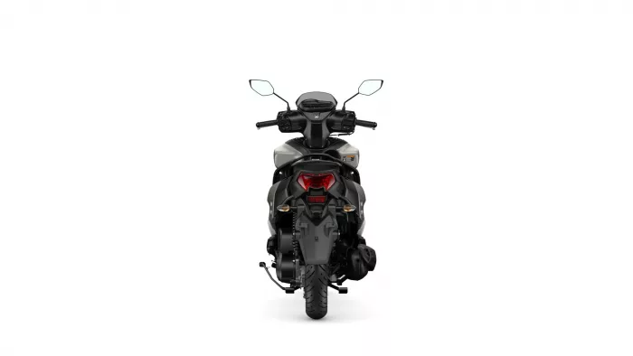 Rear view of a black motorcycle with a red taillight and cargo rack seen from behind, on a white background.