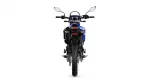 Rear view of a blue off-road motorcycle, showing the red taillight, mirrors, and a knobby rear tire.