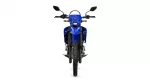 Front view of a blue adventure motorcycle with knobby tires facing straight ahead