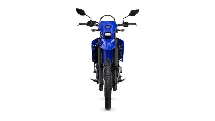 Front view of a blue adventure motorcycle with knobby tires facing straight ahead
