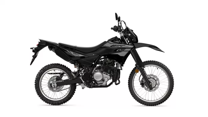 Side view of a black Yamaha off-road motorcycle with knobby tires and exposed engine against a white background