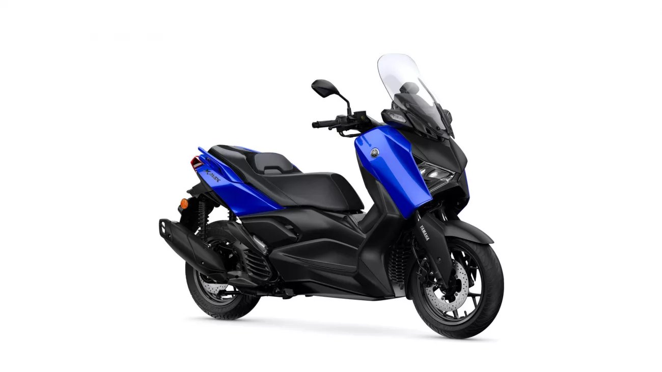Side view of a blue and black Yamaha scooter with a tall windshield and visible front wheel detail.
