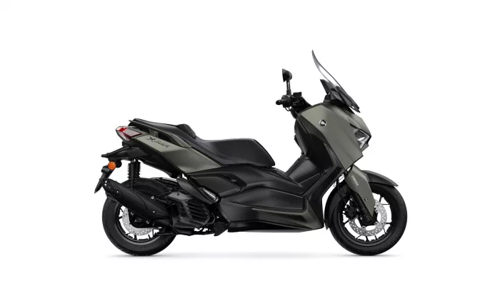 Side view of a matte olive-green Yamaha XMAX sport scooter with a windshield and disc brakes on front wheel.
