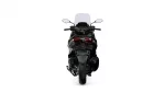 Rear view of a black sport motorcycle with a tall windshield and red taillights against a white background.