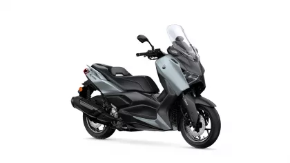 Gray and black Yamaha XMAX scooter shown in a three-quarter front view with a tall windshield