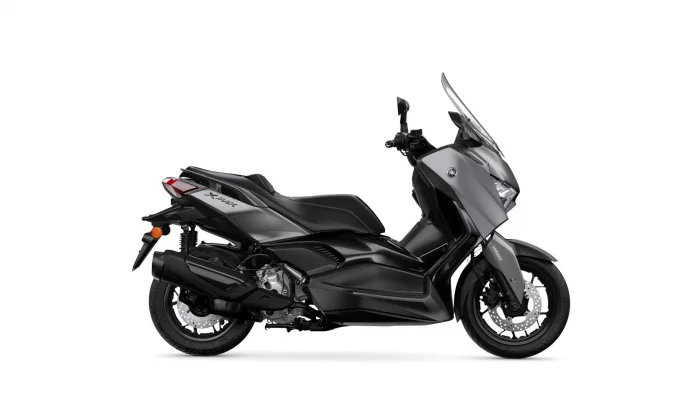 Side view of a black Yamaha XMAX sport scooter against a white background, showing windshield and front fairing
