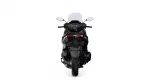 Rear view of a black sport motorcycle with a tall windshield and red taillights