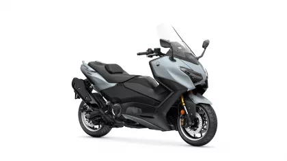 Three-quarter front view of a blue-gray Yamaha TMAX sport scooter with windshield and black accents