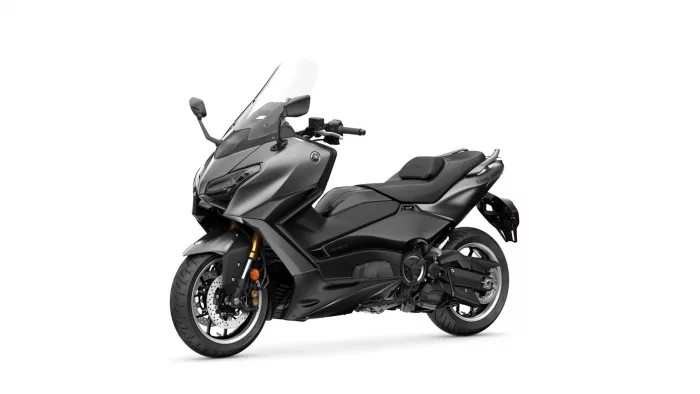 Gray Yamaha TMAX sport scooter pictured from the front-left side with a tall windshield and cockpit mirrors visible to the viewer (studio shot).