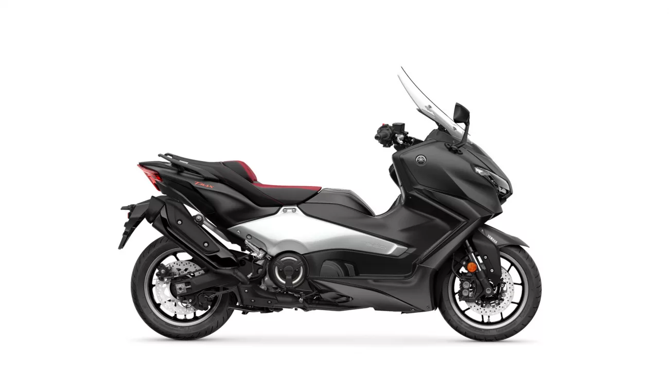 Side view of a black Yamaha Tmax maxi-scooter with a tall windshield and red seat accents.