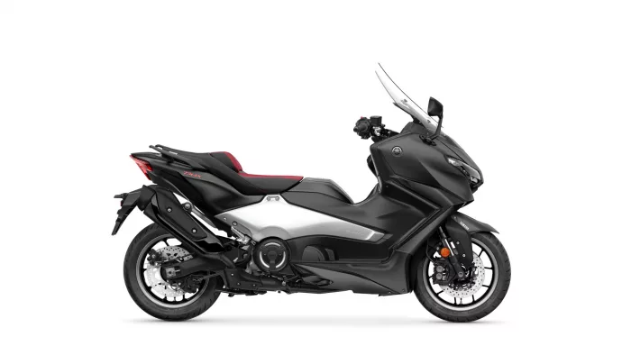 Side view of a black Yamaha Tmax maxi-scooter with a tall windshield and red seat accents.