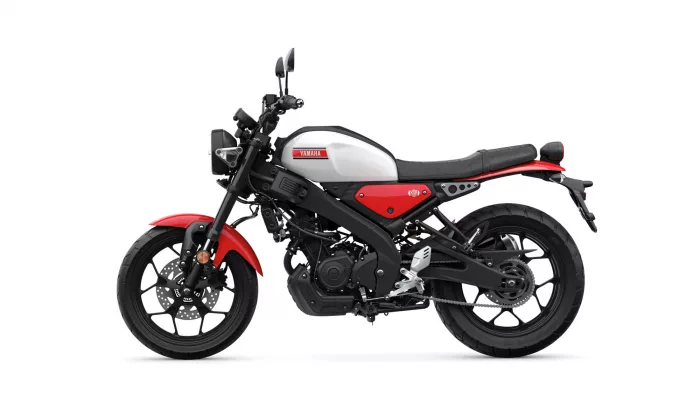 Side view of a white-and-red Yamaha motorcycle against a white background, showing its fuel tank, seat, and wheels