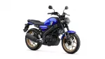 Blue Yamaha motorcycle with black frame and gold wheels, shown from a side angle with a round headlight and exhaust visible.