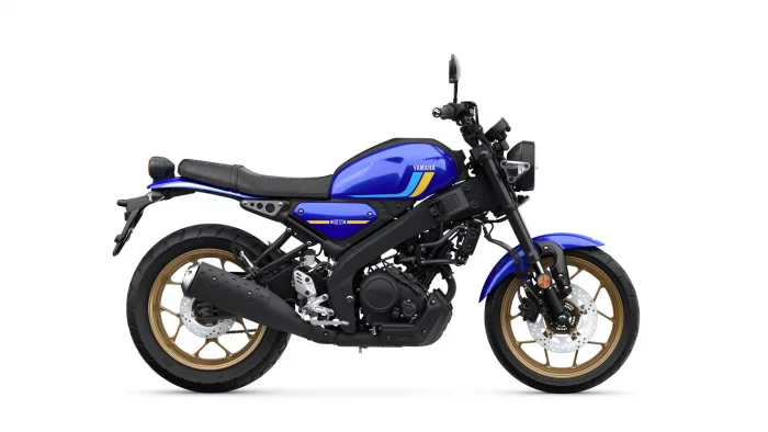 Side view of a blue Yamaha motorcycle with gold wheels and black frame, showing the fuel tank and seat