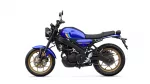 Blue Yamaha motorcycle in a left-side profile with gold alloy wheels and black frame on a white background