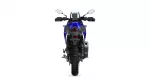 Rear view of a blue adventure motorcycle showing taillight, wide rear tire, and exhaust on the right side.