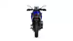 Rear view of a blue adventure motorcycle, showing tail light, rear tire, and exhaust on the right side.
