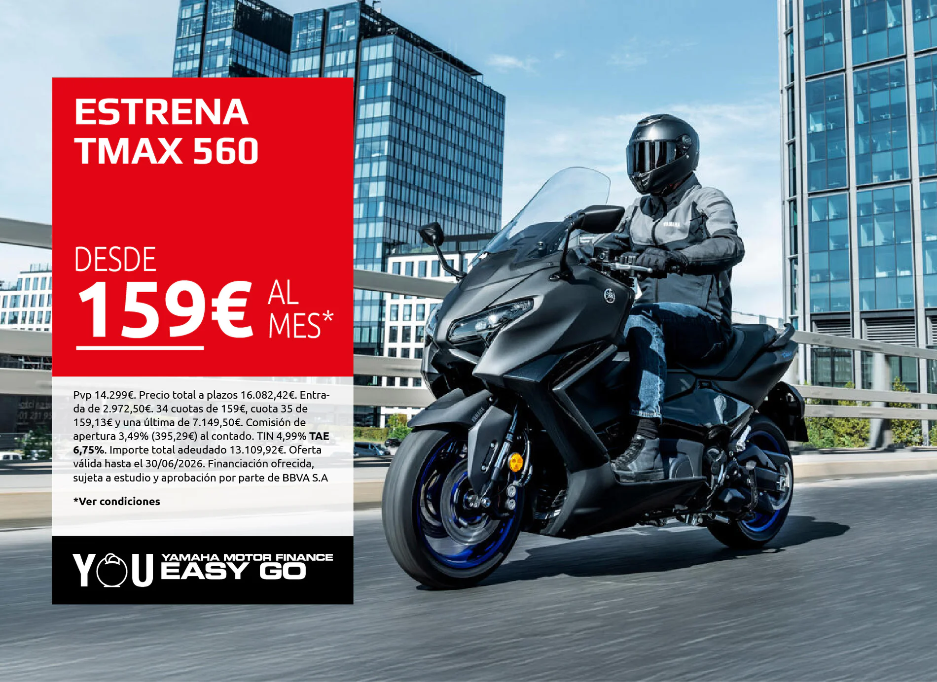 Motorcyclist on a Yamaha bike rides beside a large red promo banner that reads 'ESTRENA TMAX 560' in an urban setting.