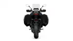 Rear view of a black touring motorcycle with large side panniers and a windscreen against a white background, showing taillight and rear tire.