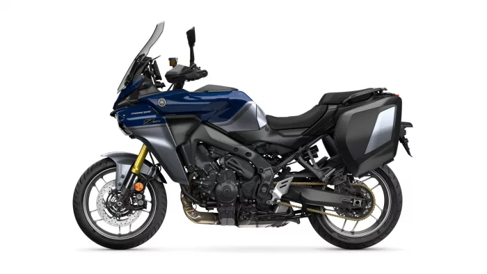 Blue Yamaha Tracer 9 GT adventure motorcycle shown from the left side with dark side panniers and a tall windshield for touring.