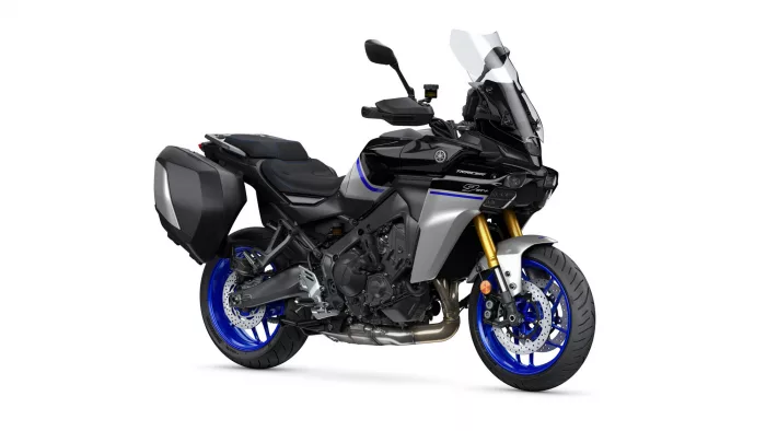 Black sport-t touring motorcycle with blue rims and side hard panniers, shown in profile with tall clear windshield and gold front forks behind.
