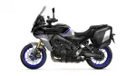 Black Yamaha Tracer motorcycle shown in profile with blue accents and silver side panniers, isolated on white background.