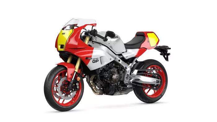 Three-quarter front view of a red and white sport motorcycle with yellow front fairing on a white background, showing its details and red wheels.