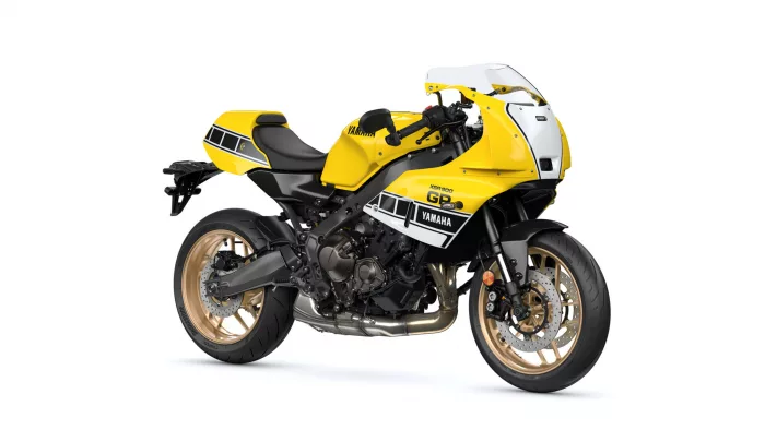 Yellow Yamaha sport motorcycle with black frame and gold wheels, viewed from the side on a white background