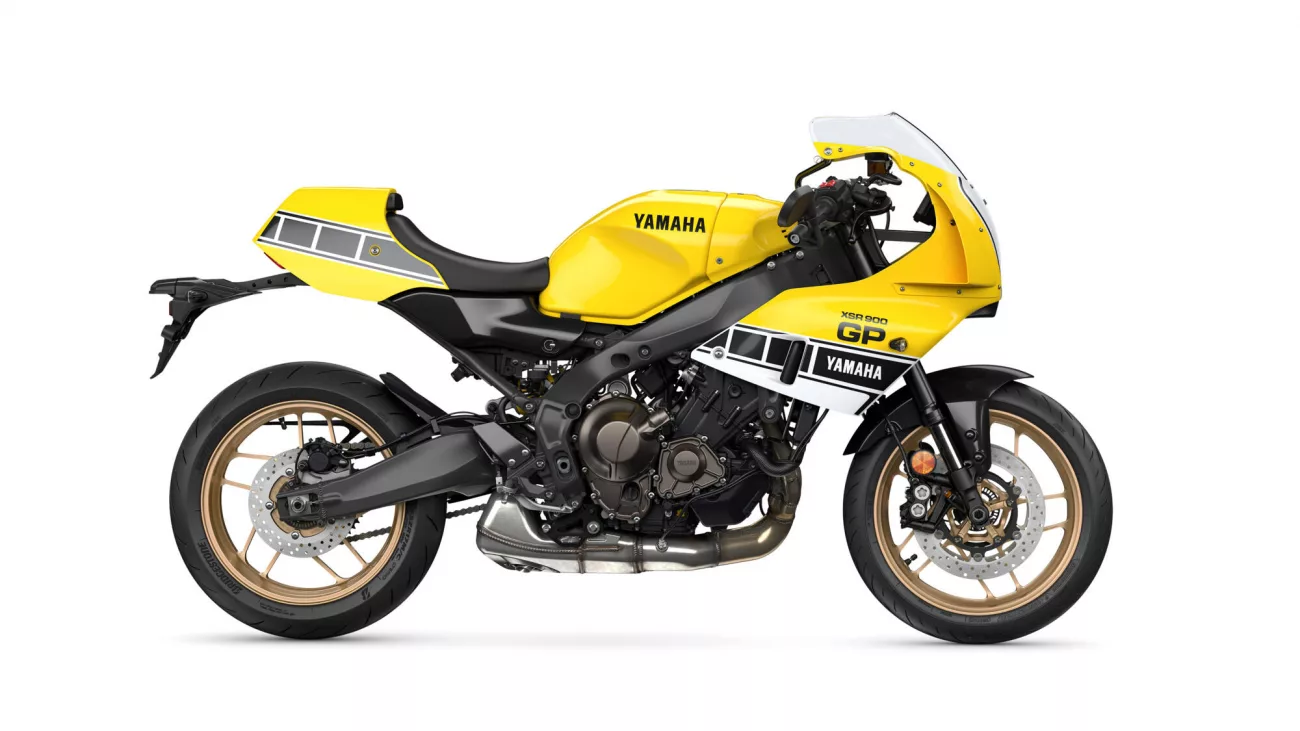 Yellow Yamaha XSR900 GP motorcycle shown in a left-side profile with gold wheels and black frame on a white background.