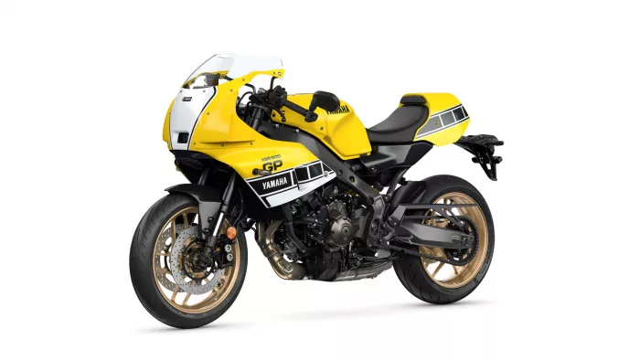 Side view of a yellow Yamaha sport motorcycle with gold rims on a white background