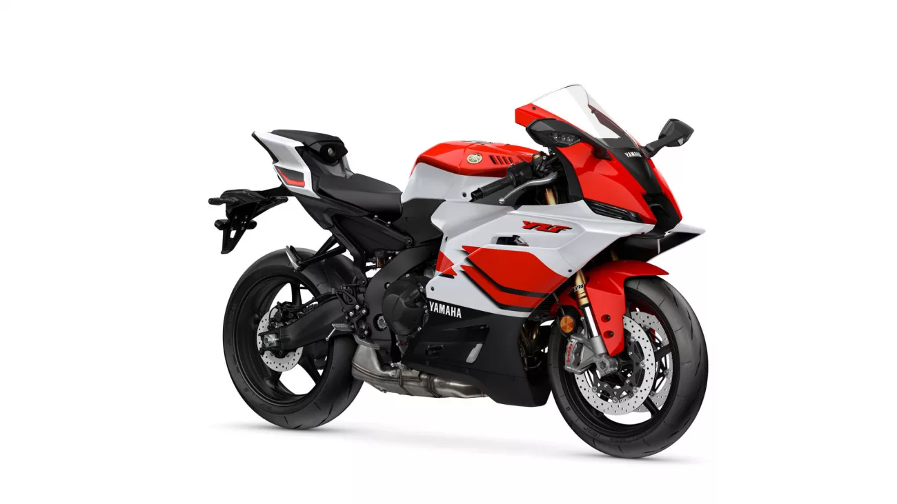 Side view of a red and white Yamaha sport motorcycle with a black seat and exposed front disc brakes.