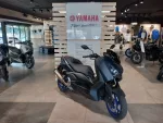 Yamaha motorcycle showroom with multiple bikes on display and a central white sign reading 'YAMAHA Revs Your Heart' behind a white slatted partition.