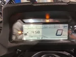 Digital motorcycle instrument cluster showing 0 km/h speed, tachometer up to 9,000 rpm, fuel gauge, and an odometer reading 5,512 km with warning lights on (orange engine light) and an orange H indicator at top.