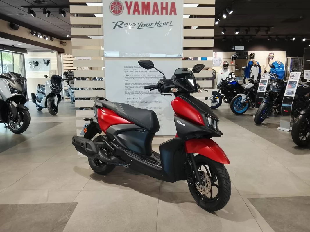 Yamaha motorcycle showroom with red and black scooter in the foreground and several bikes on display in the background.